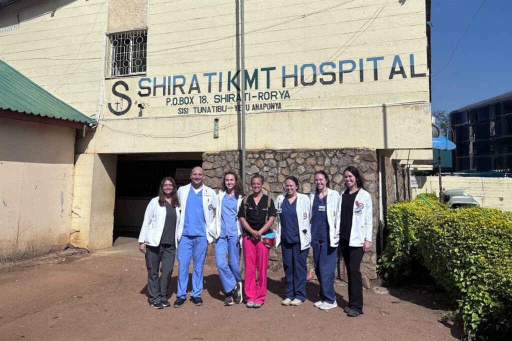A group of medical providers standing in front of a building