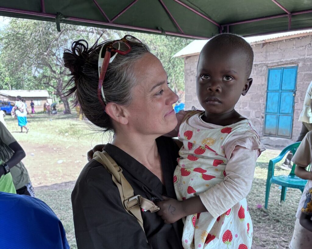 Bryn Kroto Holds a child.