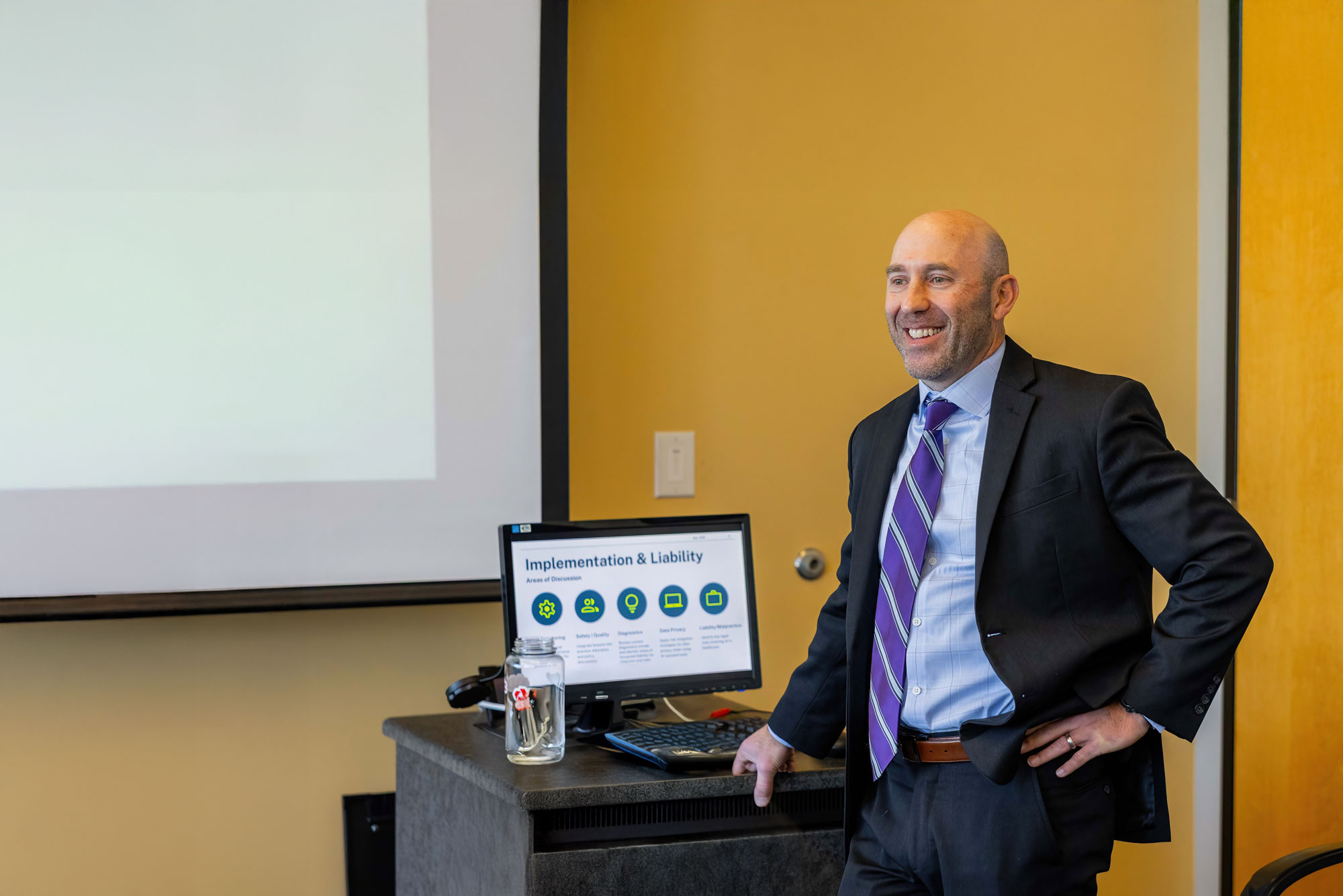 Instructor presents a health care management lesson in a classroom, reflecting coursework in MHA programs online.