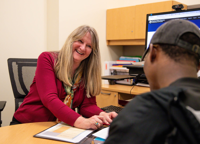 Relationship Building in the Workplace during a friendly one-on-one meeting across a desk in an office.