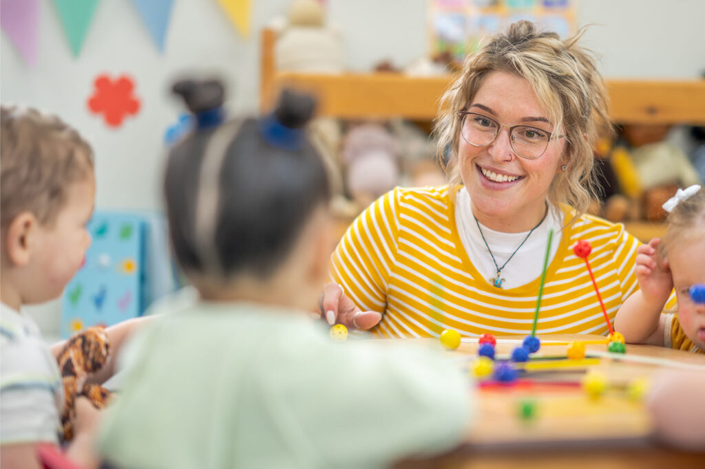 Teacher guiding young children in an inclusive classroom activity representing modern practices shaped by the history of special education.