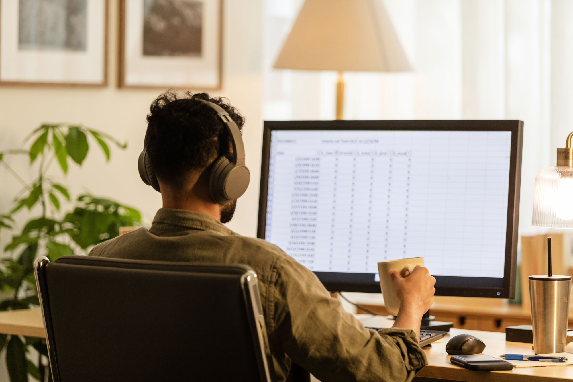 Professional works at a desktop computer while reviewing spreadsheet data, representing an Excel course focused on data analysis, reporting, and workplace productivity.